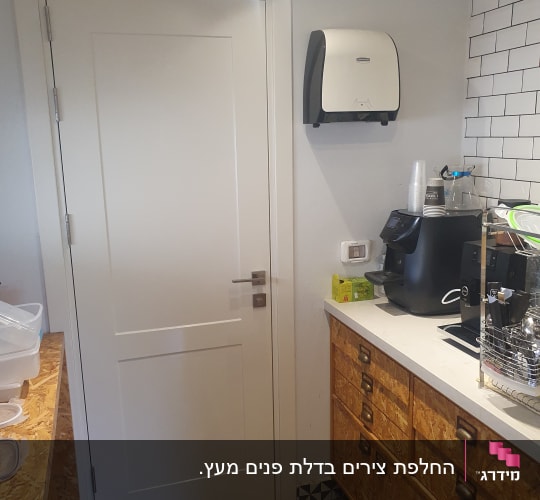 דלת לבנה עם ידית מתכת בחדר מטבח